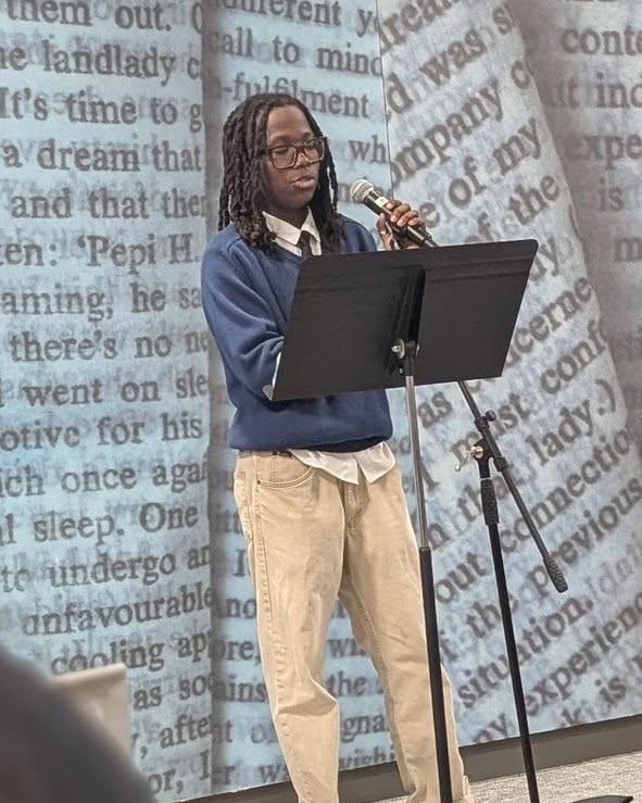 Student reading from a microphone during an event