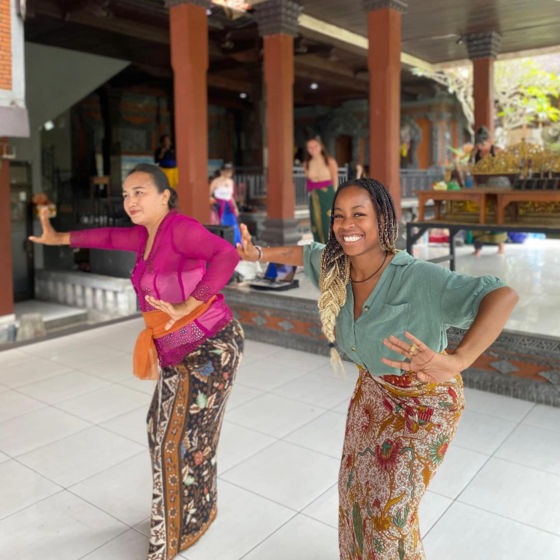 Student smiling and doing a traditional Bali dance while studying abroad
