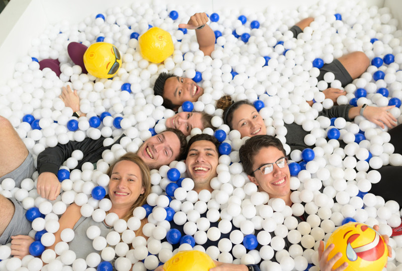 students posing for a picture while in a white and blue ball pit