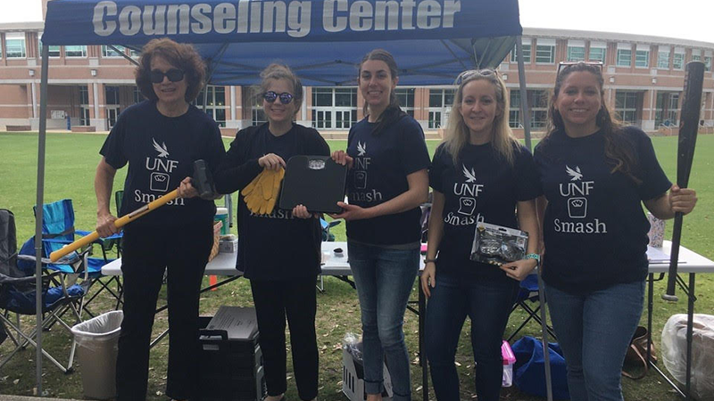 Counseling Center tent with five volunteers wearing t-shirts that say UNF Smash