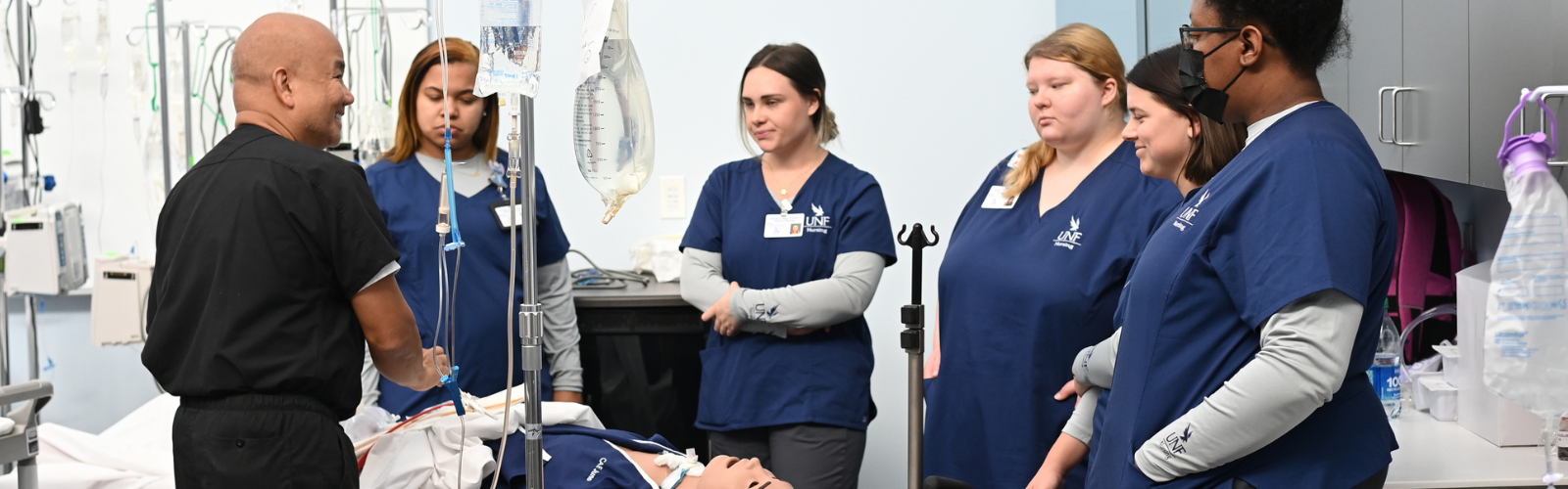Nursing faculty member with five female nursing students learning about the cadaver