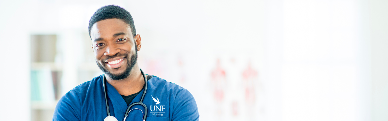 male nurse smiling wearing a blue UNF scrub