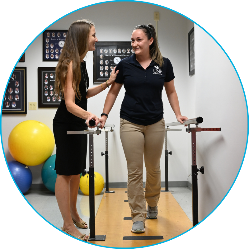 Professor Pinkstaff assisting a student on a physical therapy walker path