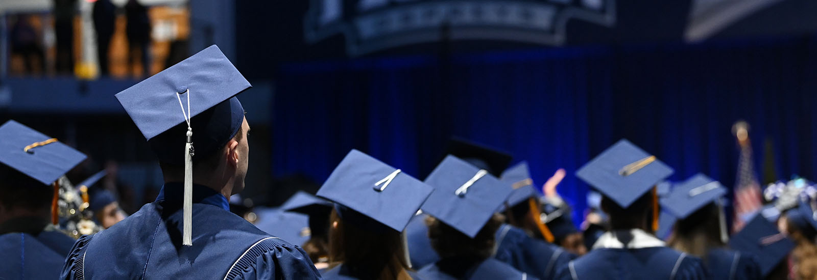 a crowd of graduates looking toward the stage