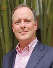 Professional headshot of Dr. Brown standing in front of bamboo.