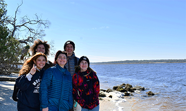 Five individuals on the beach.