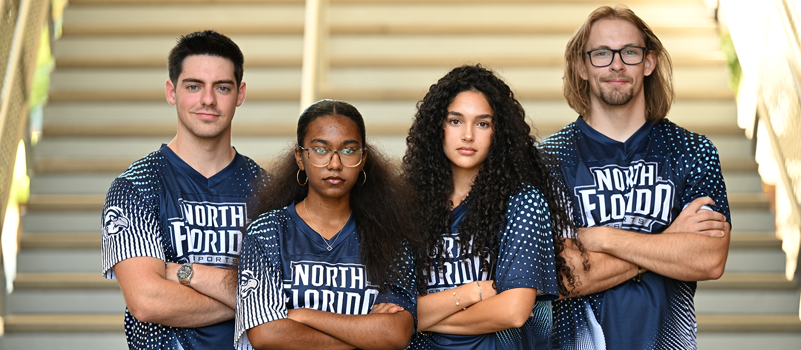 Four students wearing UNF Esports Jerseys