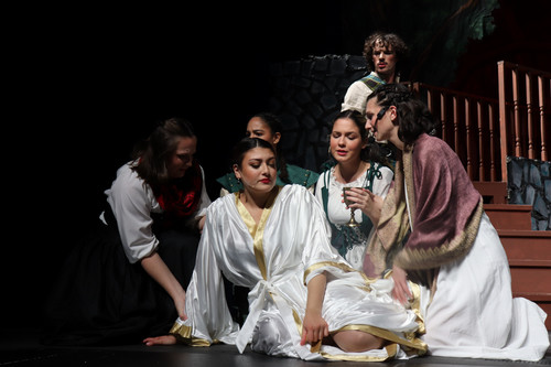 Lady MacBeth surrounded by four attendants who console her.