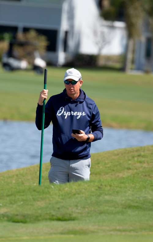UNF head golf coach Scott Schroeder walking a golf course