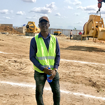 Makaya Malila standing on a construction site in Tanzania