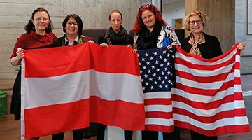 Aleksandra Jama, Birgit Münzer, Eva Sacherer, Dagmar Schnepf and Sherry Shaw holding up an Austrian and an American flag