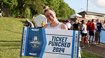 Smilla Kolbe holding a NCAA ticket-shaped sign that reads "Ticket Punched 2024"