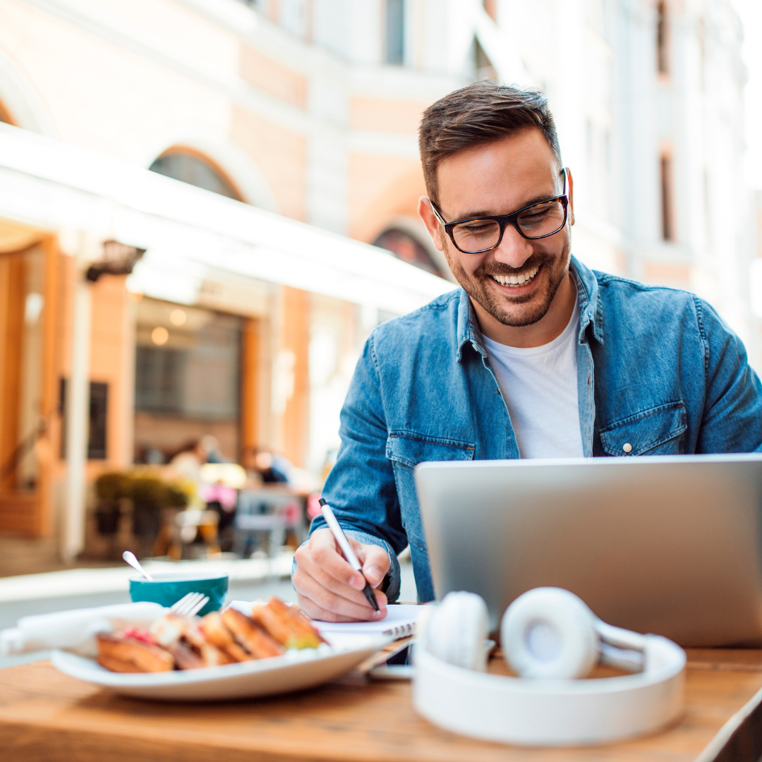 man working on his computer at a cafe