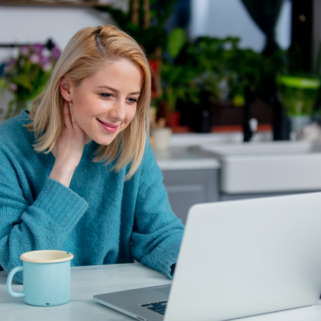 woman looking at her laptop on her porch