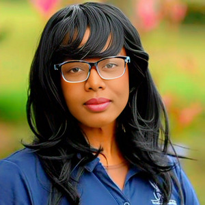 Headshot of Eric Hughes wearing glasses with a blurred background