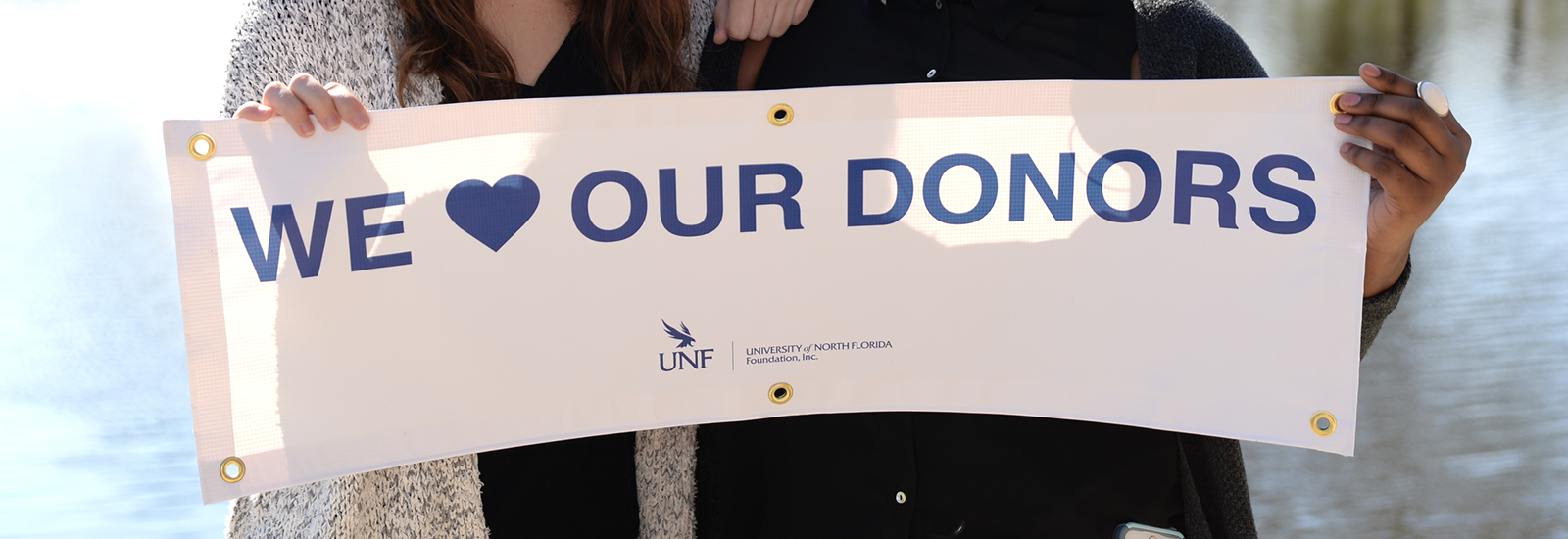 two Ospreys holding up a banner that says we love our donors