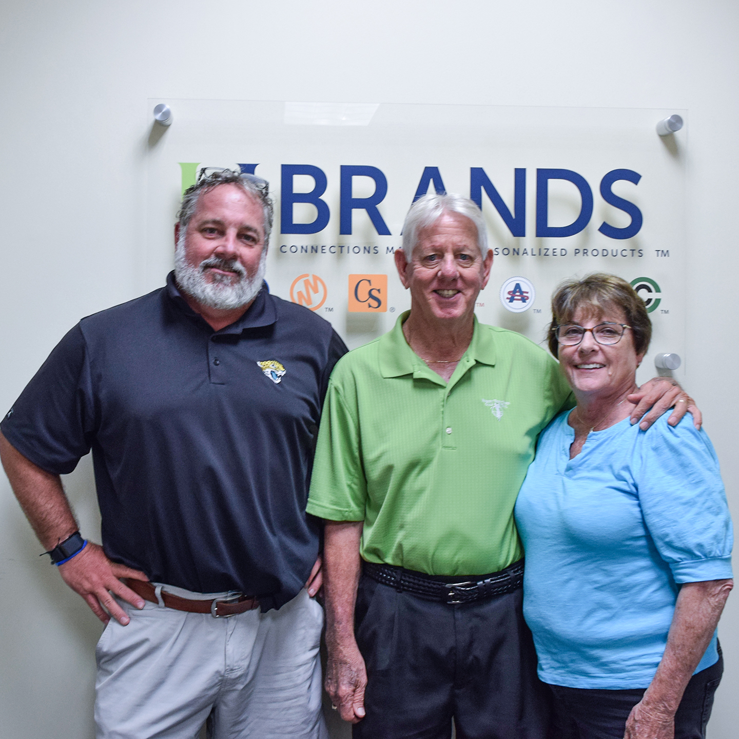 Bryan, Bob and Eileen Croft standing in front of their HC Brands company sign