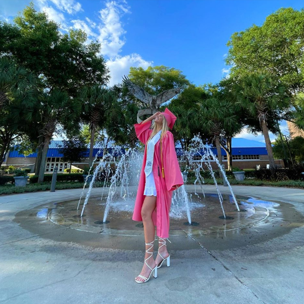 kendall posing in her regalia in front of the osprey fountain