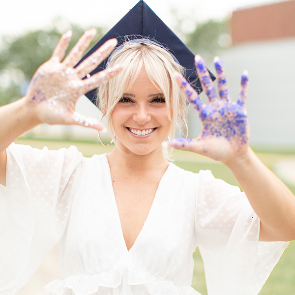 syd in grad cap showing off her hands full of glitter