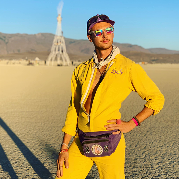 vince wearing a yellow jumpsuit in a desert